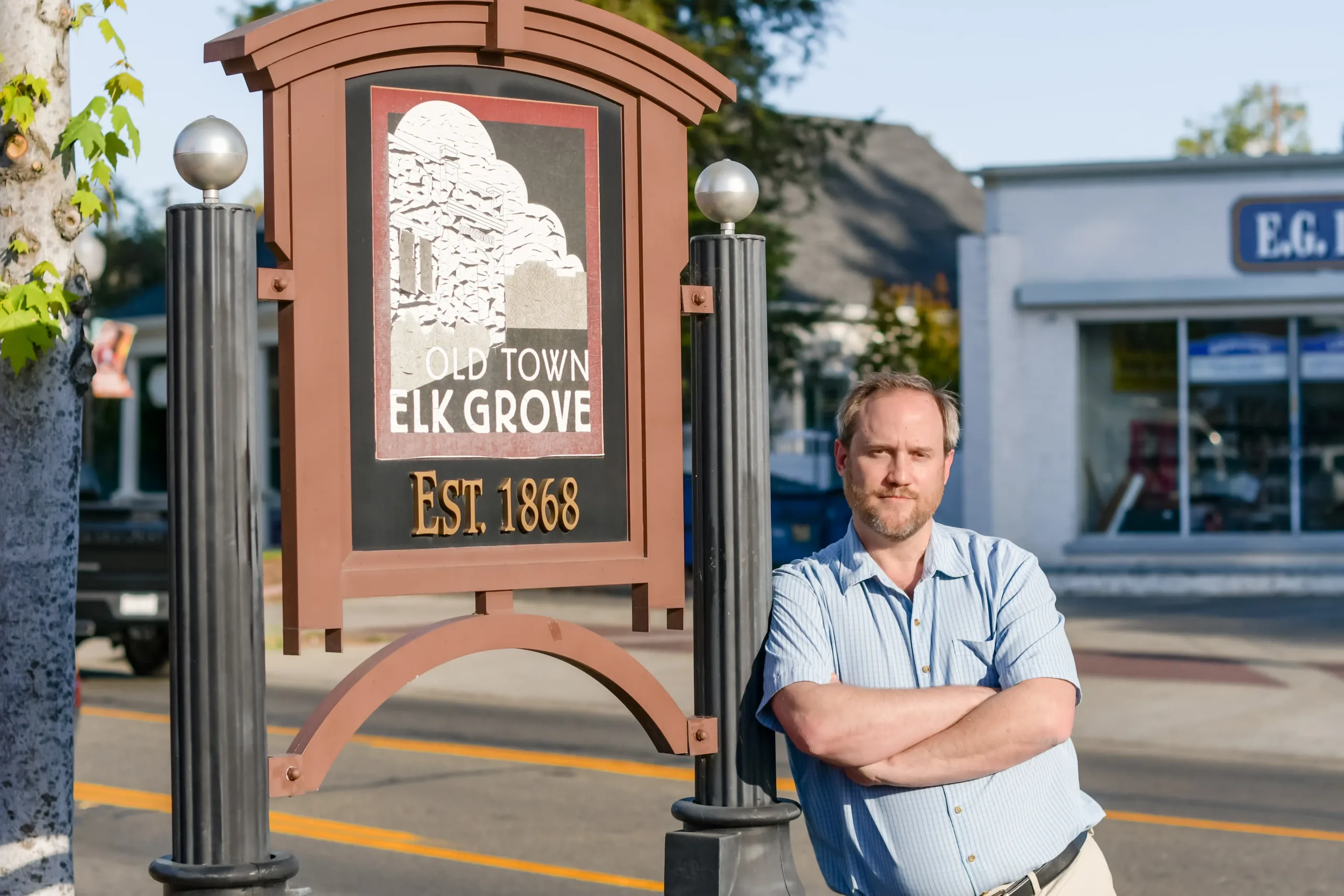 Newman 8 Isaac Newman, plaintiff in Newman v. EGEA, leaning against an Elk Grove town sign in California.