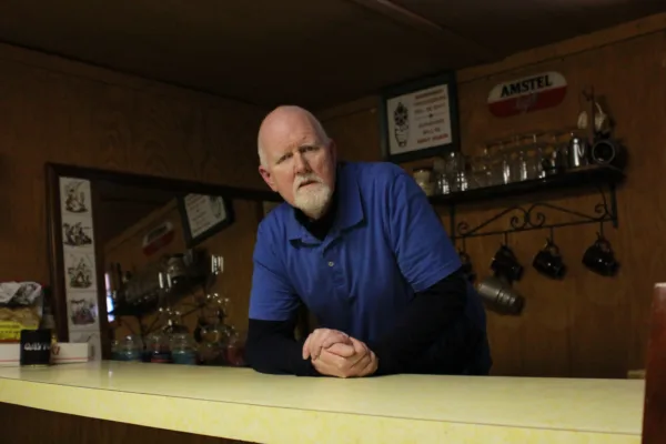 John Kabler, plaintiff in Kabler v. UFCW, Local 1776, leaning against a counter with glasses hanging on the wall behind him.