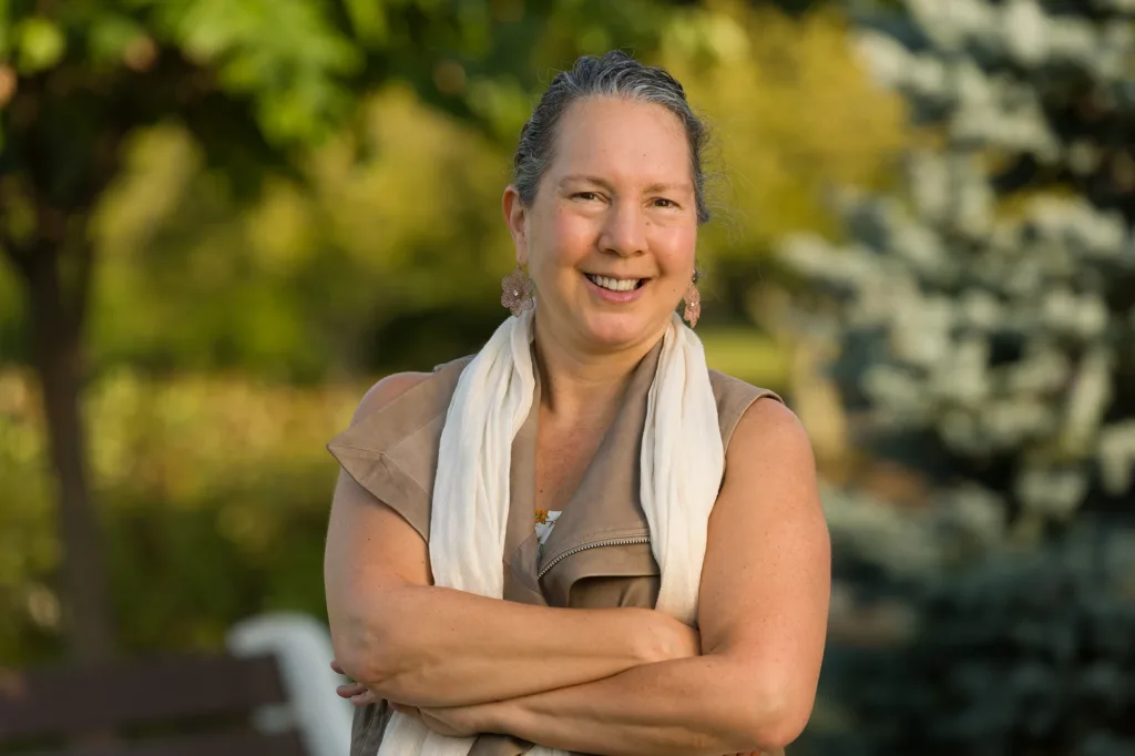 Woman in brown blouse with white scarf posing outdoors