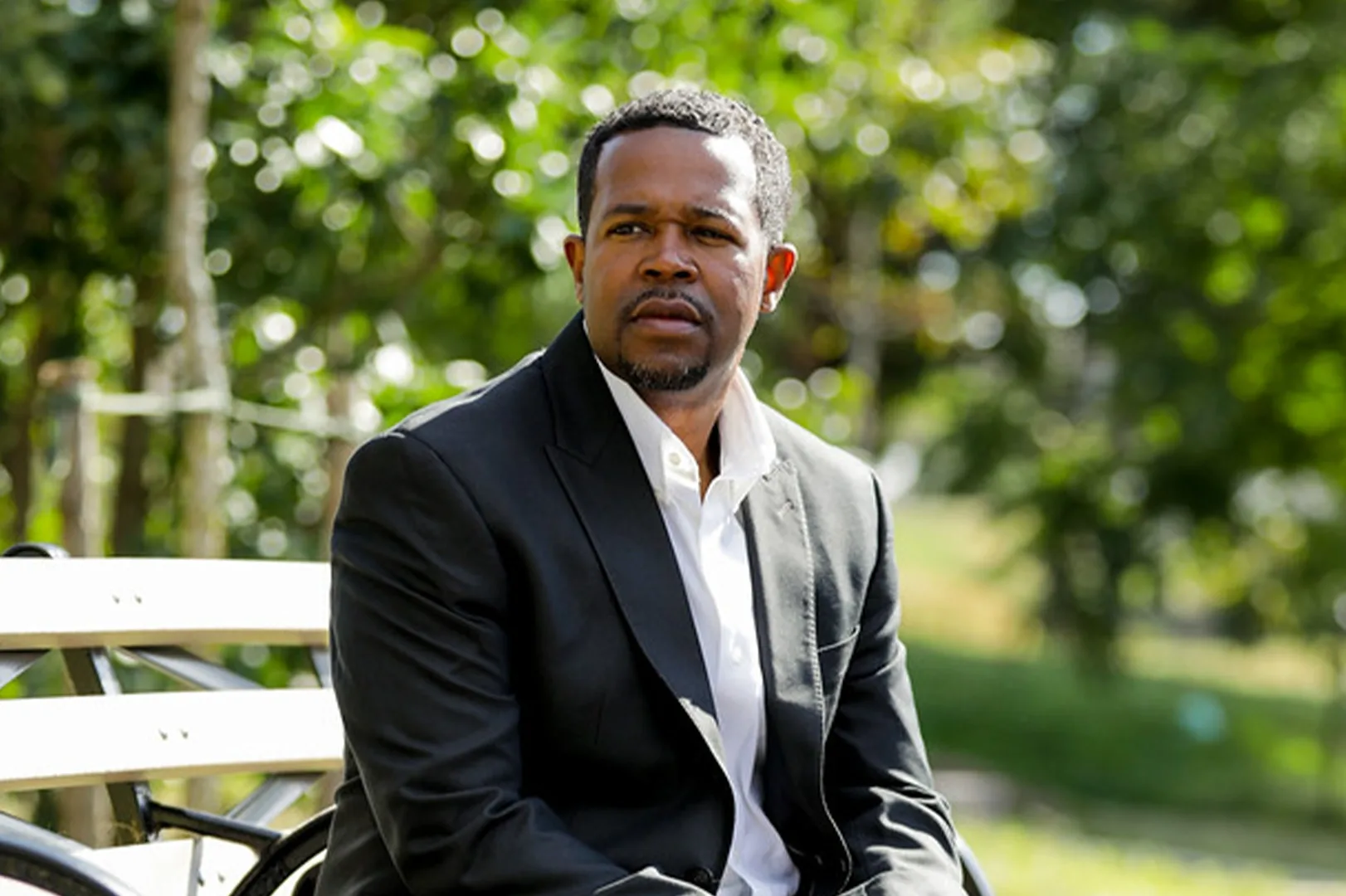 Seabron_Hompeage Photo Ed Seabron, plaintiff in Seabron v. AFSCME, D.C. 37, sitting on a park bench next to a paved pathway.