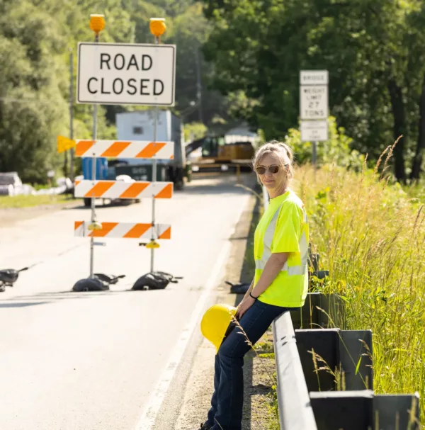 Mindy McFetridge, plaintiff in McFetridge v. AFSCME, Council 13, sitting on a guardrail in front of road construction.