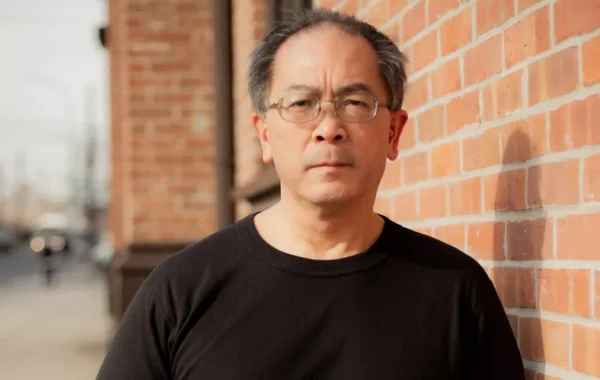 Wayne Wong, plaintiff in Wong v. TWU, Local 100, leaning an elbow against a brick wall.