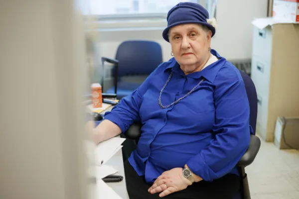 Frimette Kass, plaintiff in Goldstein v. PSC/CUNY, grading papers in her office with a serious expression on her face.
