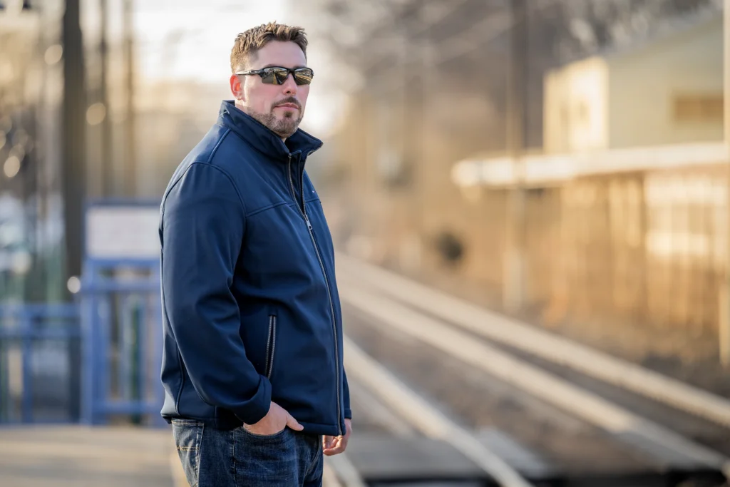 A man wearing sunglasses standing next to train tracks; Ryan Bilodeau, a plaintiff in Bilodeau v. AFSCME Local 391